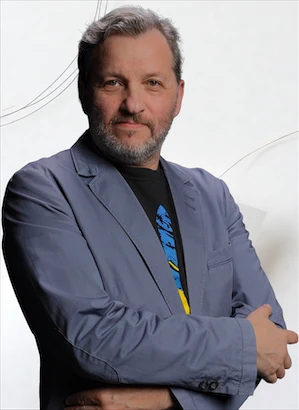 Alex, the lead video and audio production engineer at Chester WorX, wearing a professional blazer and standing against a minimalist Japanese-style background. He represents the creative and technical expertise behind the agency's high-end video storytelling, documentary film editing, and professional audio craftsman services.